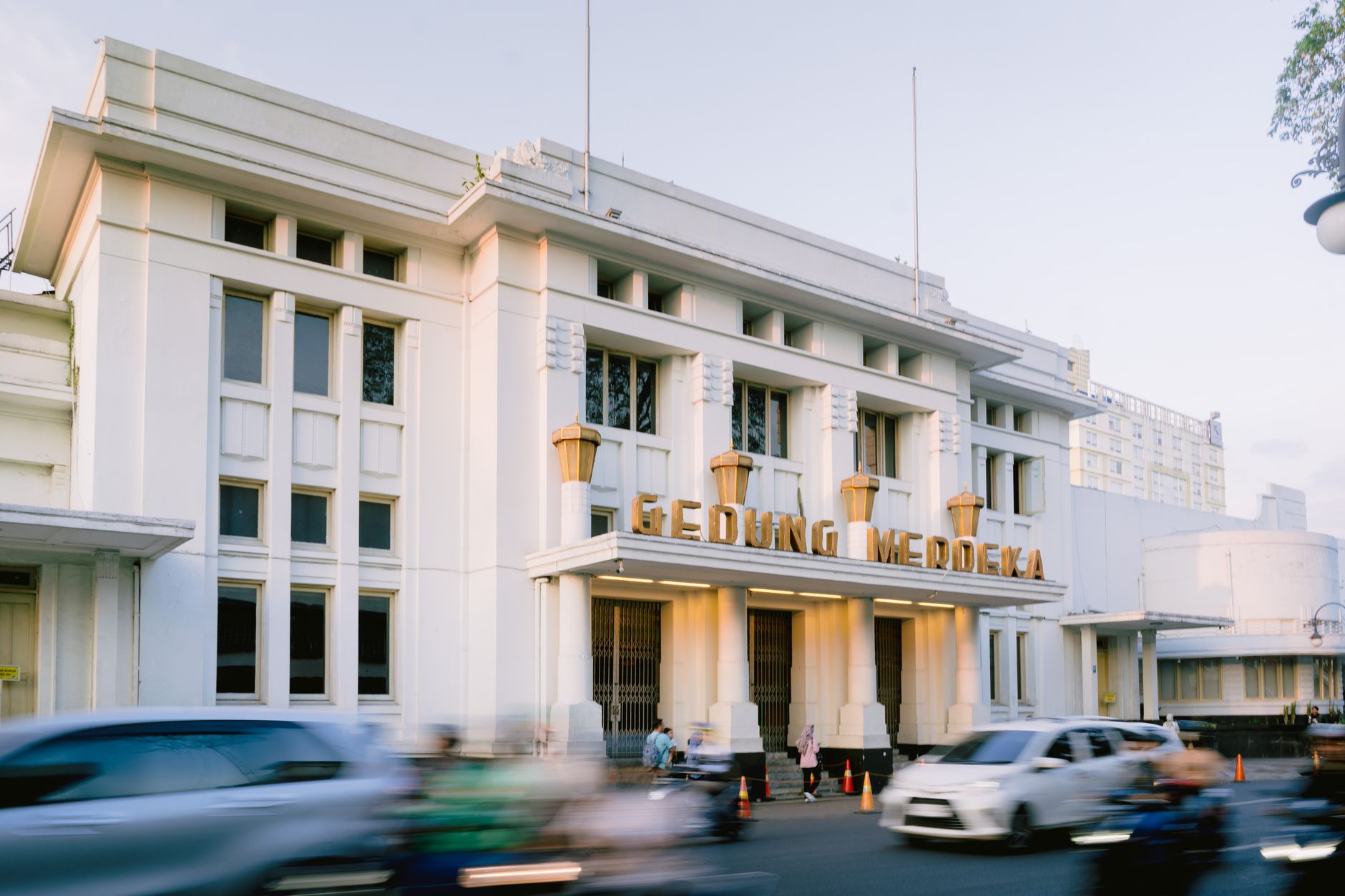 Ilustrasi pekerja profesional sedang melakukan pengecatan dinding luar gedung tinggi bertingkat.